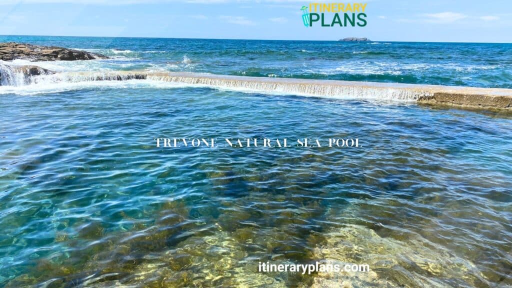 The Trevone Natural Sea Pool, with its clear waters and gentle waves, is beautifully bordered by a stone edge.