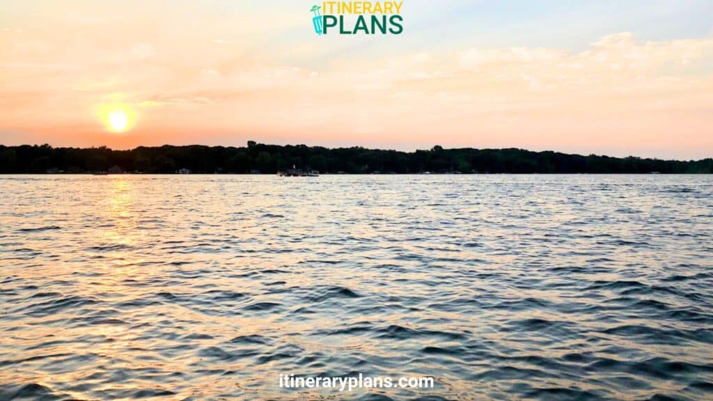 A tranquil lake at sunset with rippling water, a distant shoreline, and a boat. Big marine lake mn