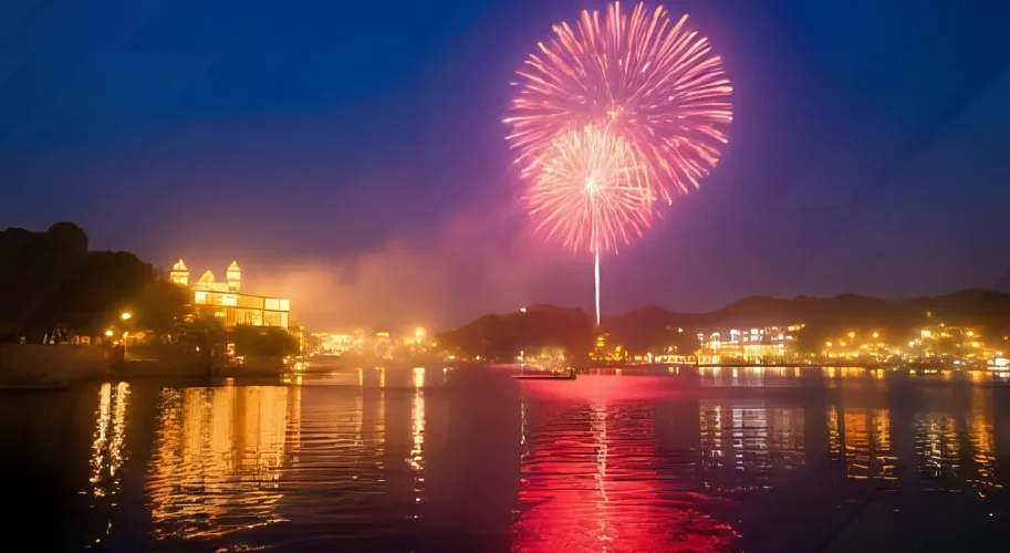 Lake Pichola reflecting palace lights and fireworks during Diwali in Udaipur.