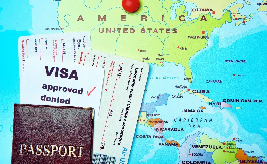 A passport and plane ticket are placed on a map highlighting the United States and Central America. A visa document marked "approved" is visible.