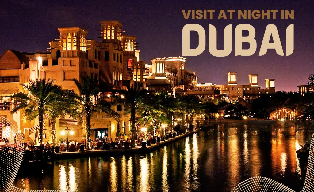 Nighttime view of Dubai with illuminated, tower-like buildings and palm trees reflected in a canal. Warm, inviting atmosphere with text: "Visit at Night in Dubai."